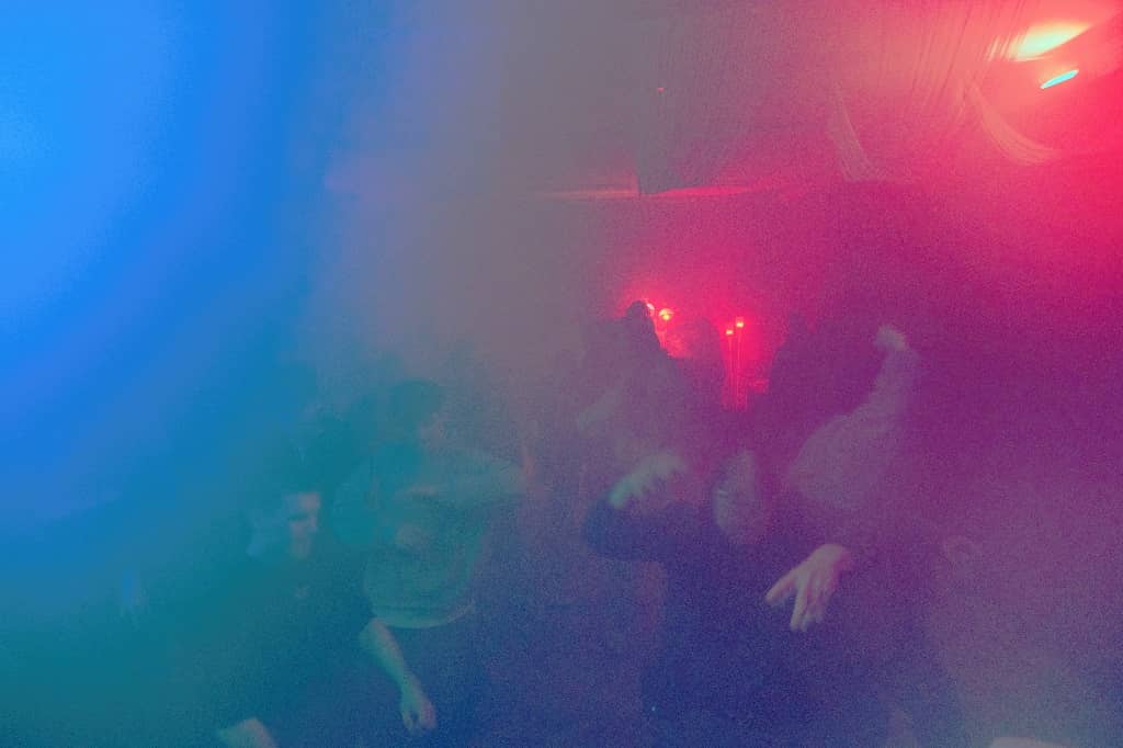 People going wild in smoke and lights at the dancefloor